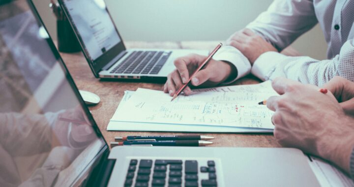 Caucasian person planning budget at bright workspace, main focus in upper frame, landscape no-text image